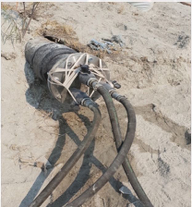 Grout delivery hoses laid out across a tailings facility