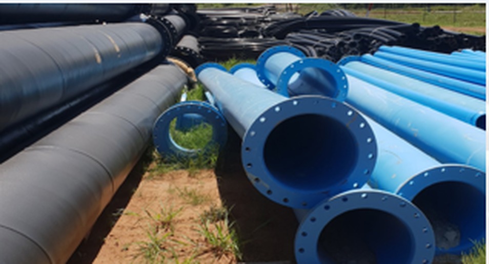 Steel and HDPE pipe sections stockpiled on a mine site ahead of installation